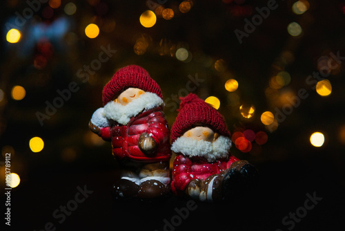 Decorative Christmas porcelain figures. Santas little helpers, Pixie. Infront of a dark background with defocused light dots. Placed in the center of the frame.