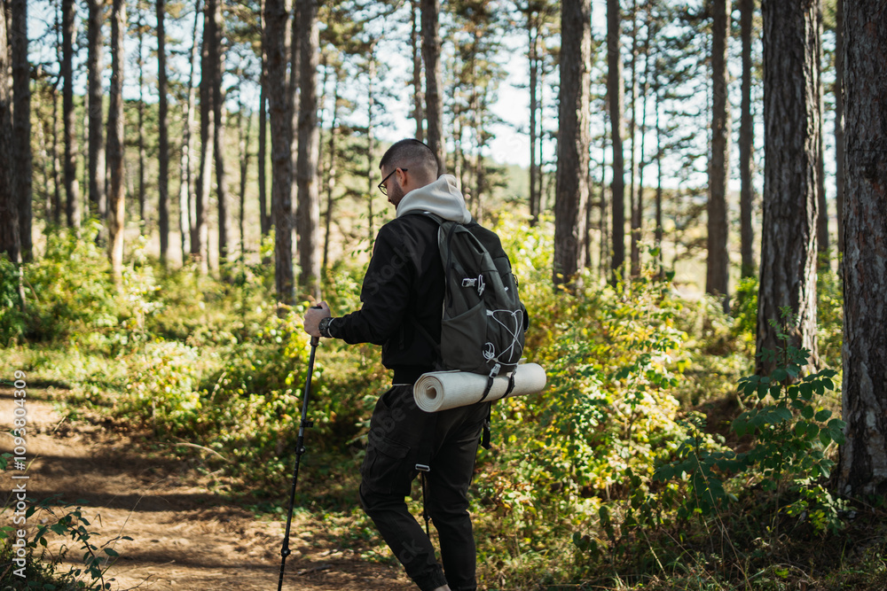 Young caucasian man hiking or trekking through the forest Young caucasian man hiking or trekking through the forest