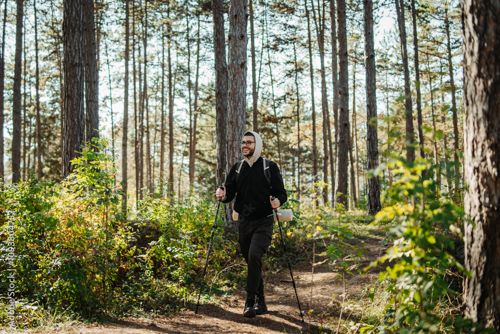 Young caucasian man hiking or trekking through the forest Young caucasian man hiking or trekking through the forest