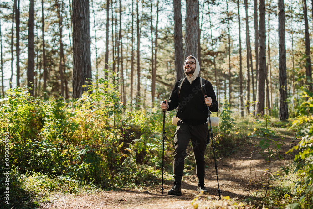 Young caucasian man hiking or trekking through the forest Young caucasian man hiking or trekking through the forest