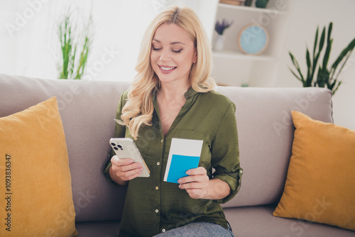 Photo of lovely adorable woman preparing flight booking hotel sitting sofa indoors flat weekend travel trip tour photo