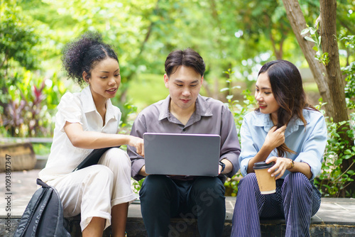 Group of people working and talking at the park.