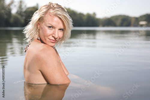 Pretty lady in summer lake posing for portrait in daytime photo