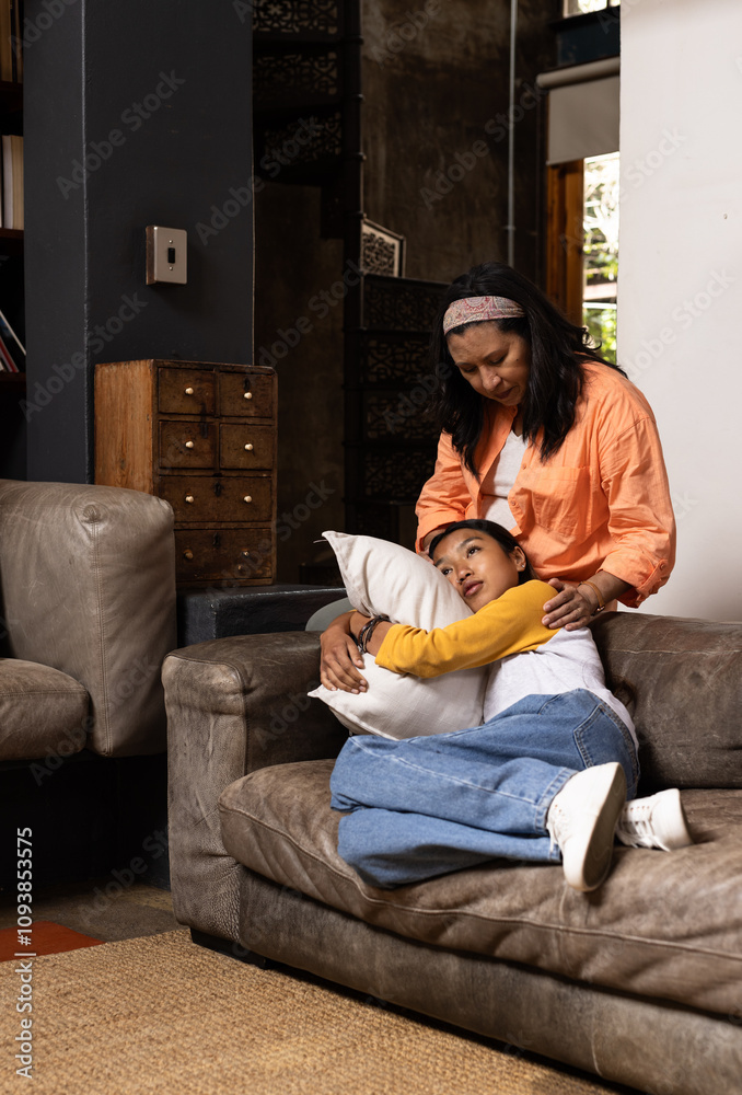 © Wavebreak Media - Grandmother comforting asian female teenager on couch at home, sharing warm family moment
