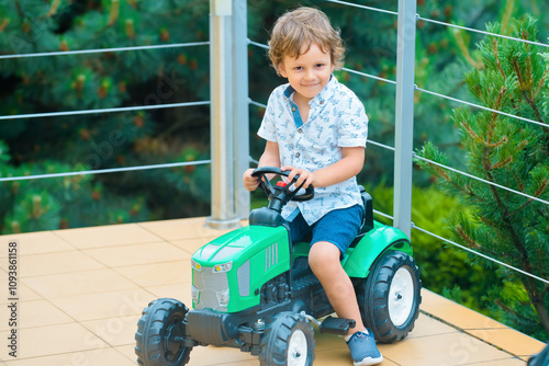 Little Driver. Cute little baby boy pretending to drive. Kid in car with hands on the wheel. Baby Driver. Little kid driving car. Kid Sitting At The Wheel. Child playing with car. Dream, imagination. photo