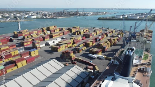 Visão aérea de contêineres no porto de Veneza, Itália, com movimentação intensa de cargas, navios e guindastes, destacando a logística portuária e o comércio internacional