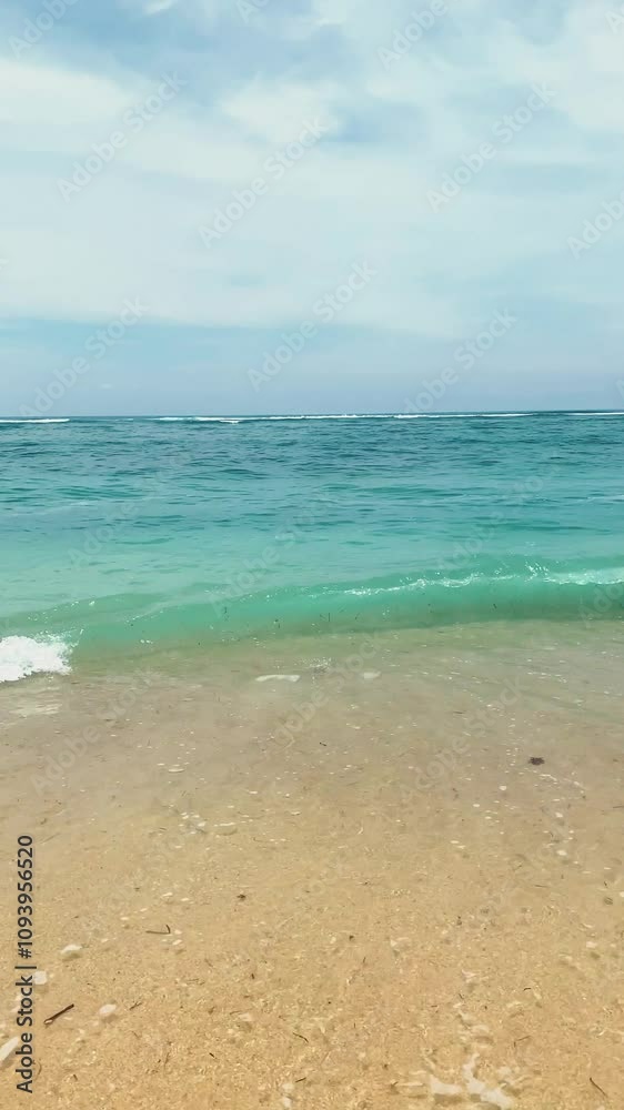 Beautiful sea and wild beach with yellow sand. Blue ocean wave on a sandy beach in Uluwatu, Bali. summer background and summer holiday concept. Beautiful sea and wild beach with yellow sand. Blue ocean wave on a sandy beach in Uluwatu, Bali. summer background and summer holiday concept.