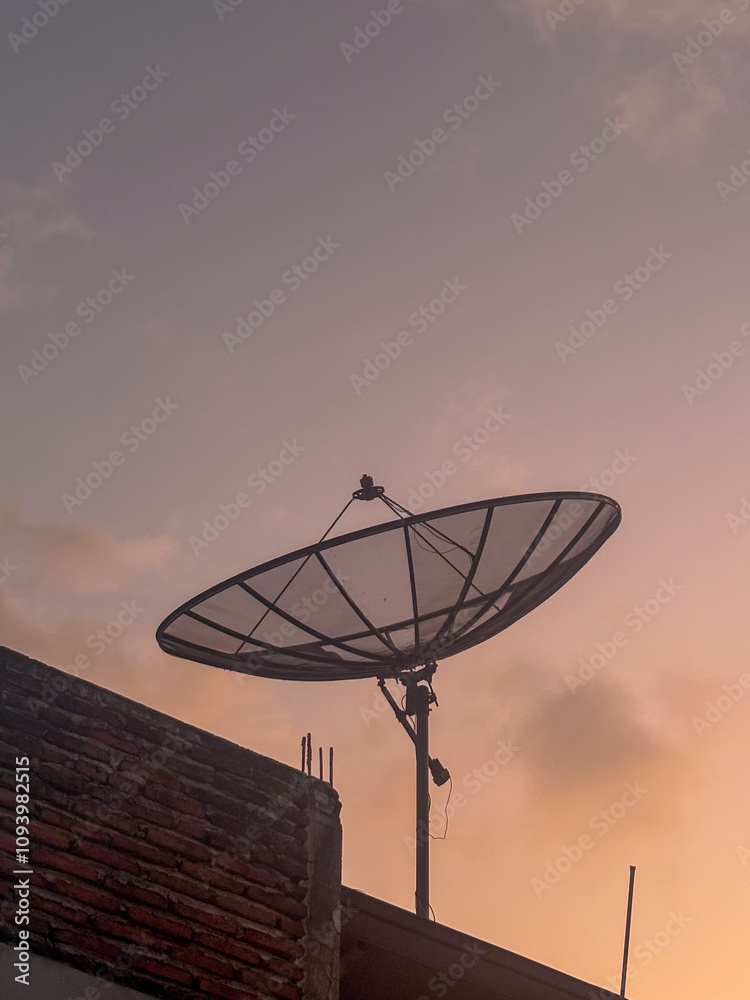 Satellite dish on the roof at sunset Satellite dish on the roof at sunset