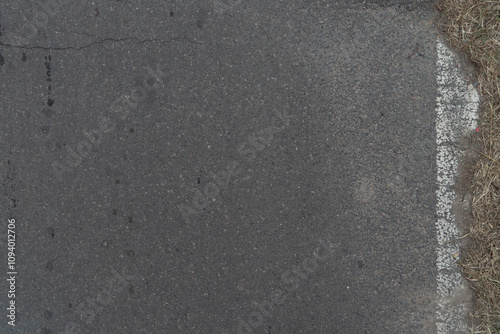 Asphalt road with barely visible white painted line in Ezeiza, Buenos Aires, Argentina.