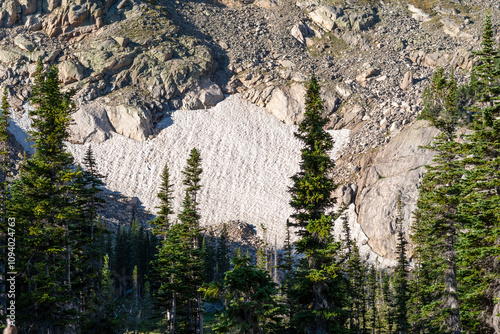 Vászonkép Glacial landscape featuring a snowfield nestled among rugged mountains and everg