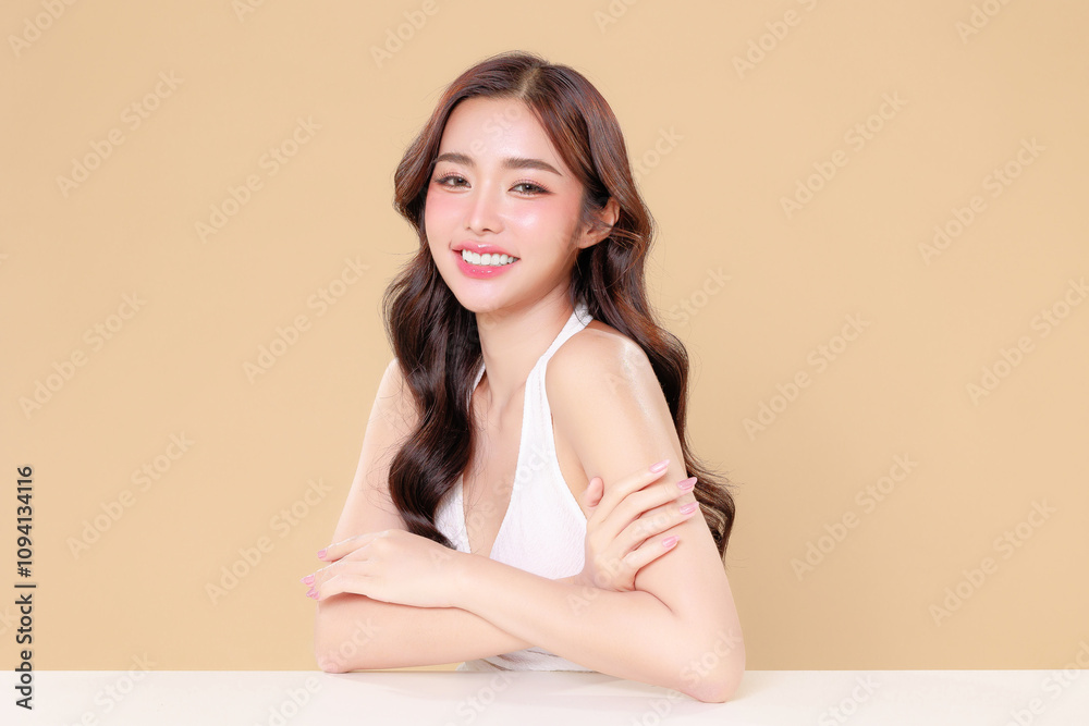 Pretty Asian beauty woman curly long hair with Korean makeup glowing face and healthy facial skin portrait smile on isolated beige background. Cosmetology ,Plastic surgery. Pretty Asian beauty woman curly long hair with Korean makeup glowing face and healthy facial skin portrait smile on isolated beige background. Cosmetology ,Plastic surgery.