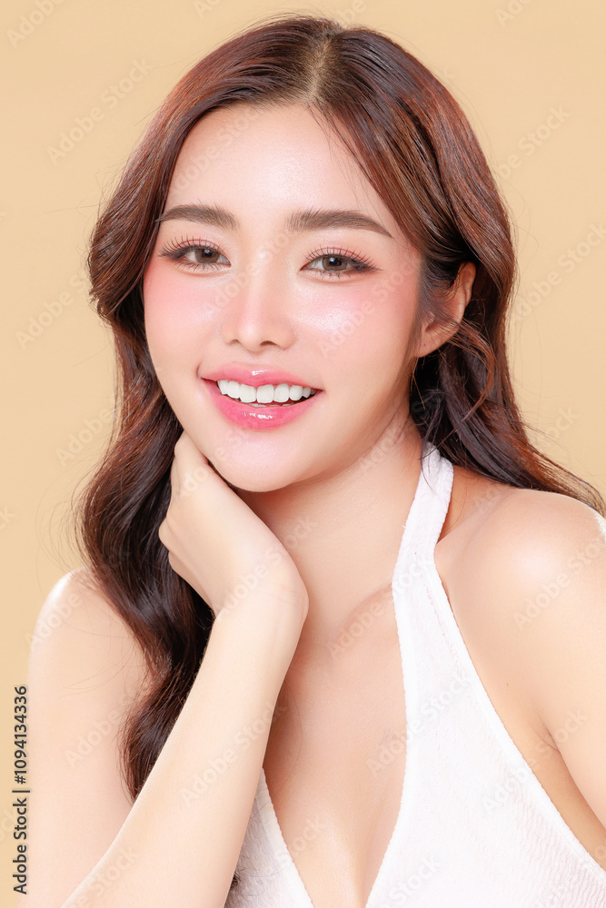 Pretty Asian beauty woman curly long hair with Korean makeup glowing face and healthy facial skin portrait smile on isolated beige background. Cosmetology ,Plastic surgery. Pretty Asian beauty woman curly long hair with Korean makeup glowing face and healthy facial skin portrait smile on isolated beige background. Cosmetology ,Plastic surgery.