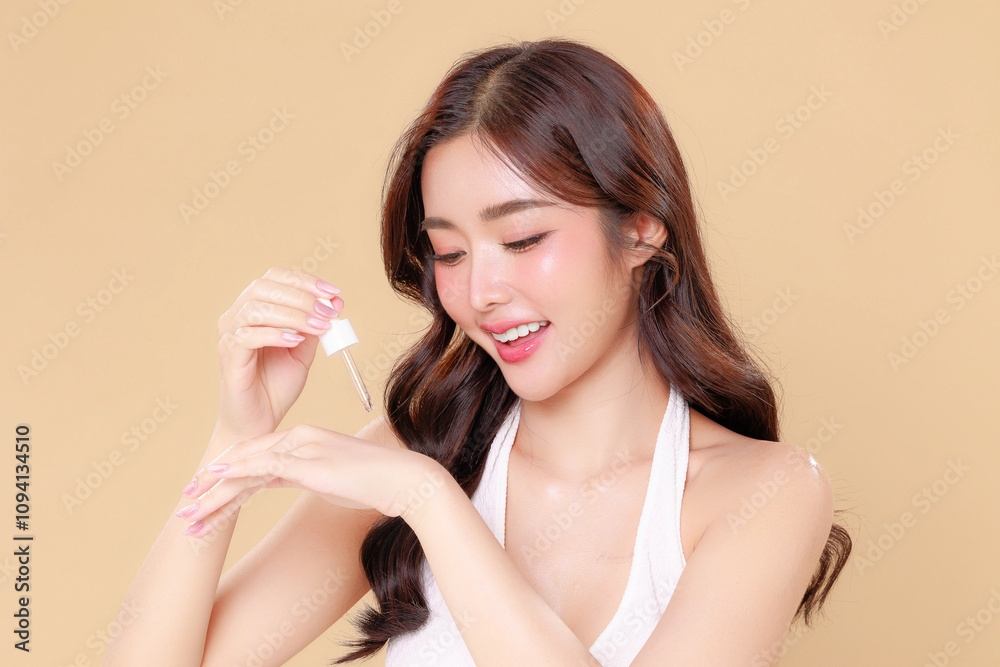 Pretty Asian beauty woman curly long hair with Korean makeup glowing face and healthy facial apply serum on skin portrait smile on isolated beige background. Cosmetology ,Plastic surgery. Pretty Asian beauty woman curly long hair with Korean makeup glowing face and healthy facial apply serum on skin portrait smile on isolated beige background. Cosmetology ,Plastic surgery.