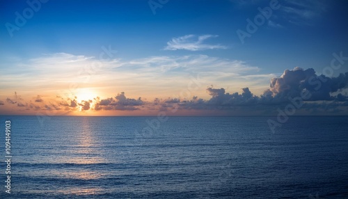 Dramatic clouds frame a breathtaking sunset over the vast expanse of the ocean