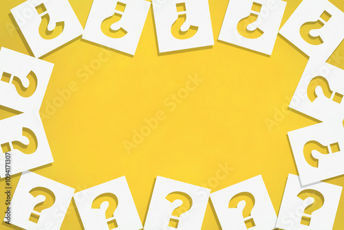 はてなマークを切り抜いた白い紙が周りに散らばったオレンジ色の背景