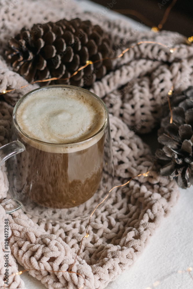 New Year, Christmas card. Coffee with milk in a glass mug among the cones on the blanket. Vertical photo New Year, Christmas card. Coffee with milk in a glass mug among the cones on the blanket. Vertical photo