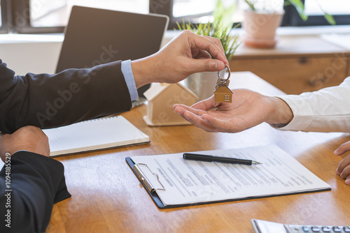 Close up agent giving a key to new owner or tenant, client after signed signature contract rental purchase, buyer apartment, home with landlord, realtor. Banker agreement mortgage loan. Property lease