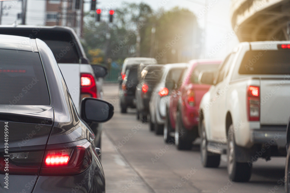 Rear side view of grey car driving on the road. with other cars. Background blurred of bridge under sky in the city. Cars lined up on the road in urgent traffic condition. Stop by traffic light. Rear side view of grey car driving on the road. with other cars. Background blurred of bridge under sky in the city. Cars lined up on the road in urgent traffic condition. Stop by traffic light.