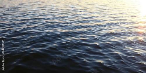 Shimmering silver wave pattern on a calm lake surface at dawn, water, serene, dawn