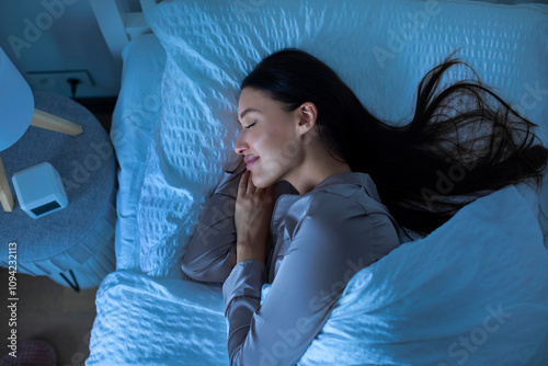 Quadro su tela Serene young woman sleeping on her side at night on bed with white linen, enjoy sweet dreams, top view