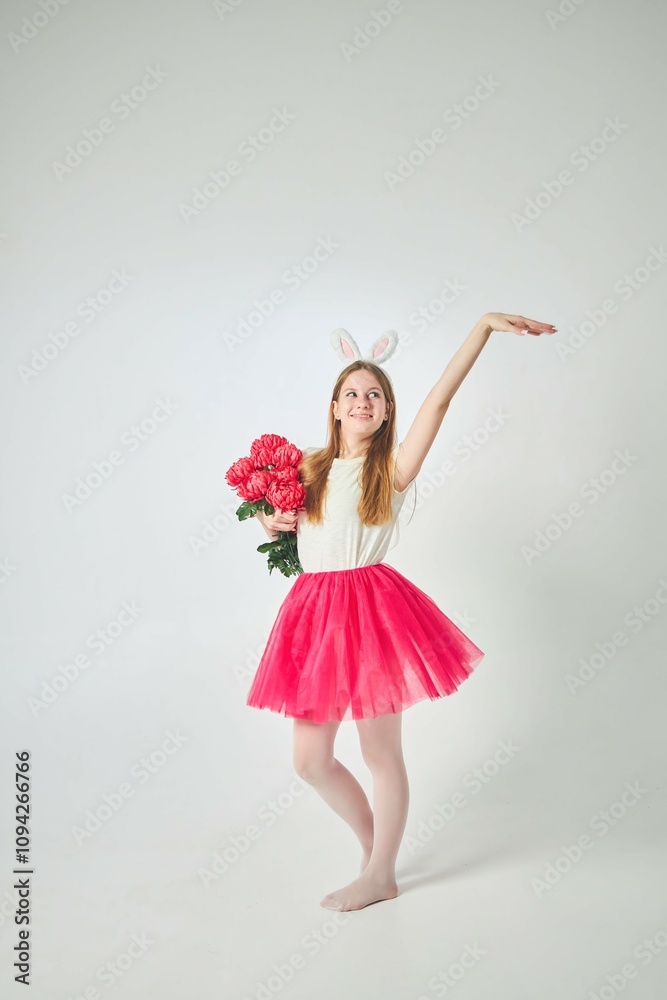 A young beautiful girl in a bunny costume and a pink skirt on a pure white background. Bouquet of red roses A young beautiful girl in a bunny costume and a pink skirt on a pure white background. Bouquet of red roses