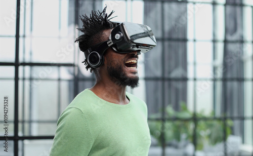 Cool handsome african american man put on virtual reality goggles for the first time in the office.