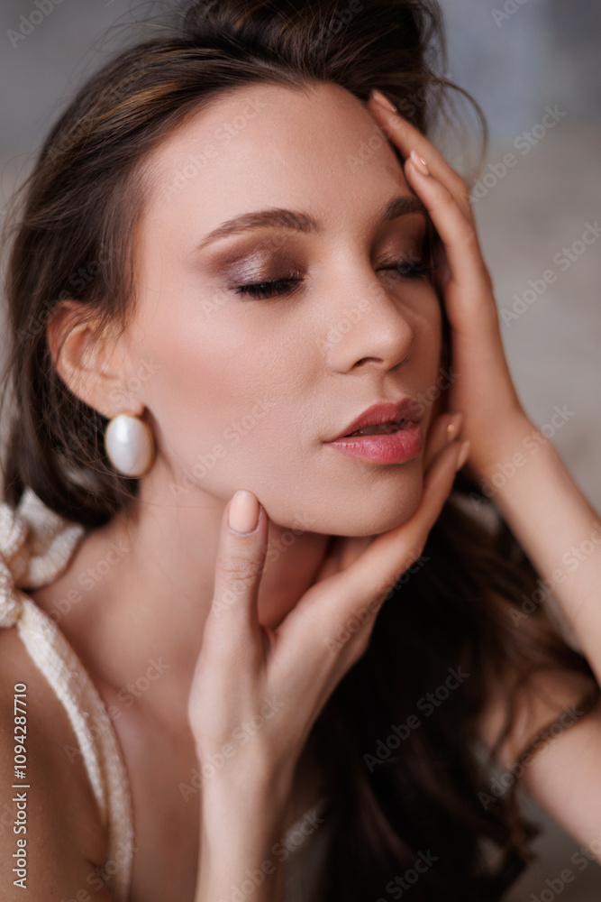 A beautiful girl in a short elegant beige gold dress stands on the sand. Portrait of a beautiful woman on a gray background. Bright make-up and long hair. Gorgeous brunette woman portrait A beautiful girl in a short elegant beige gold dress stands on the sand. Portrait of a beautiful woman on a gray background. Bright make-up and long hair. Gorgeous brunette woman portrait