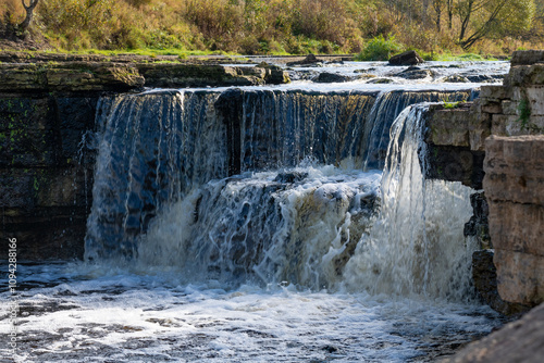 The central part of the Tosnensky waterfall on a sunny October day. Tosna River, Ulyanovka. Leningrad region, Russia photo