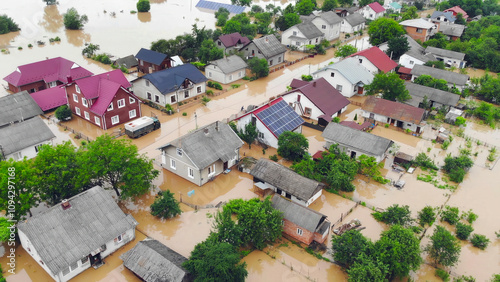 Aerial View of Flooded Residential Neighborhood. Aerial image showing a flooded residential neighborhood with homes and gardens submerged after a severe rainfall, highlighting environmental disaster.