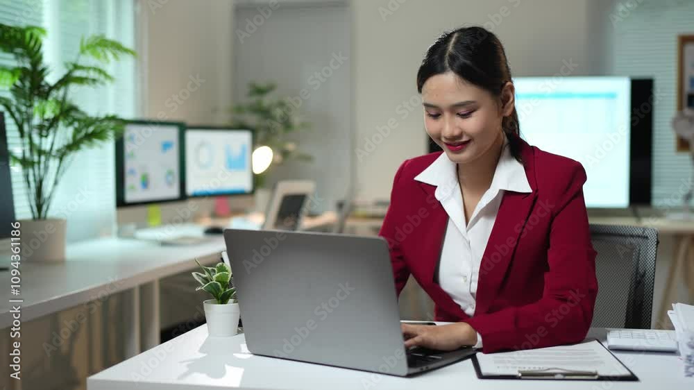 Asian businesswoman sitting in office looking at detailed graphs on laptop, PC computer, chart of real estate growth data, online financial documents in modern office. Asian businesswoman sitting in office looking at detailed graphs on laptop, PC computer, chart of real estate growth data, online financial documents in modern office.