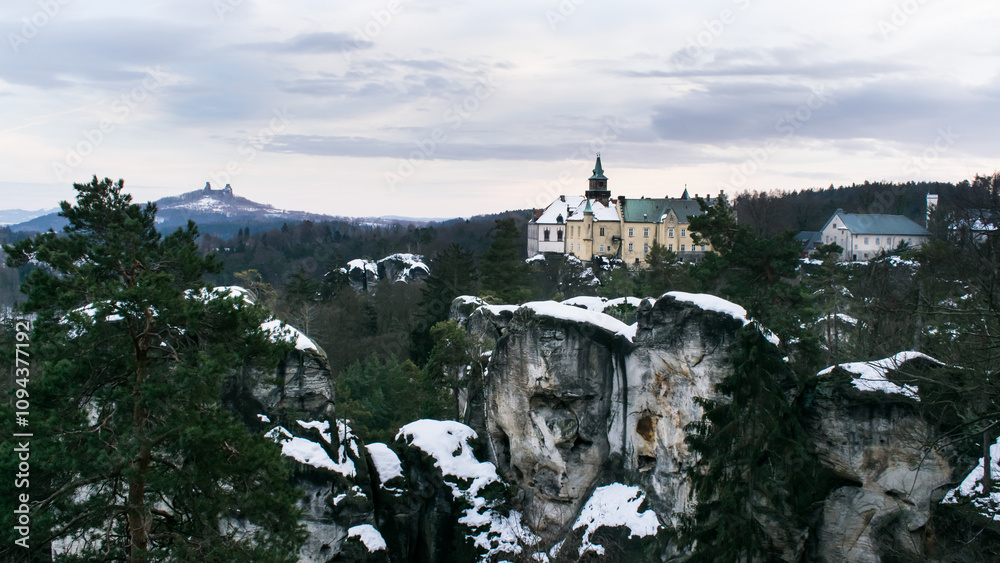 Winter panorama of the Hruboskalské rock town with Hrubá skála castle. The ruins of Trosky Castle can be seen in the distance. Winter panorama of the Hruboskalské rock town with Hrubá skála castle. The ruins of Trosky Castle can be seen in the distance.