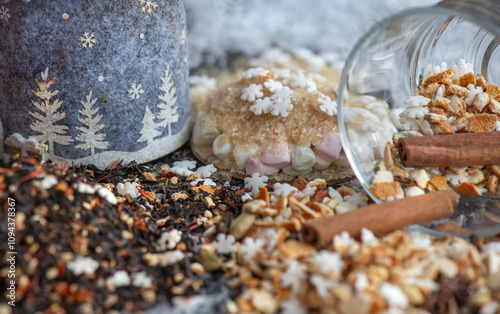 winter hot drink ingredient spiled  with spices, star-shaped and sugar  and  glass  cup turn over on  snowy background photo