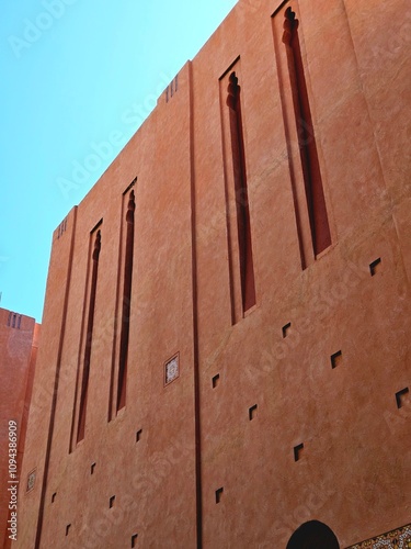 Beautiful Moroccan-style hotel building with blue sky and sunlight. Abstract portrait wallpaper.