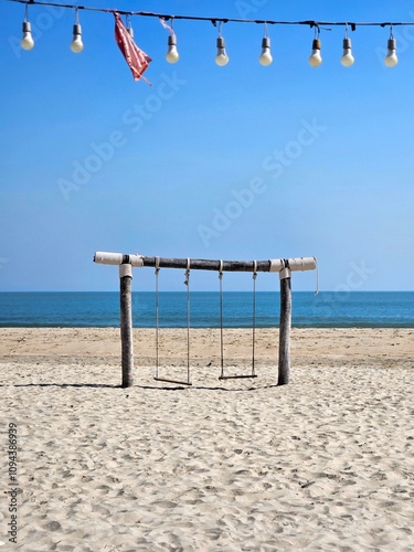 Outdoor wooden swing at the beach with beautiful sea view. Abstract portrait wallpaper.