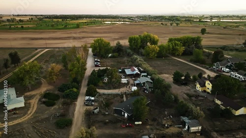 Drone shot of a large farm layout in Longmont with open fields, barns, and surrounding farmland photo