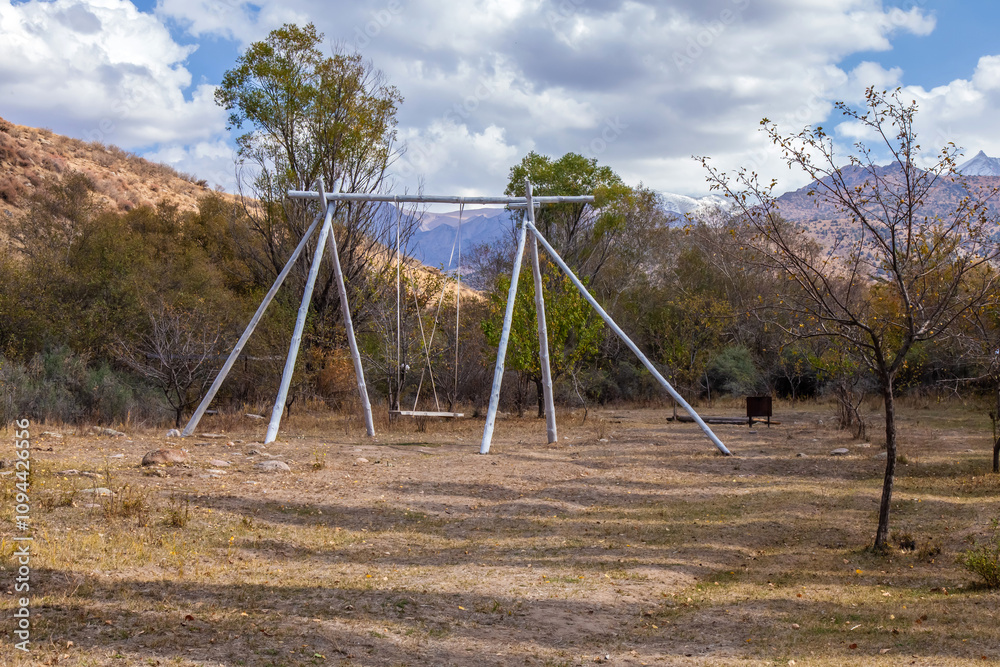Kazakh national swing in nature against the backdrop of mountains Kazakh national swing in nature against the backdrop of mountains