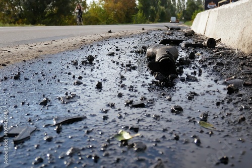 Spilled oil and parts from a broken car after an accident on the track. photo