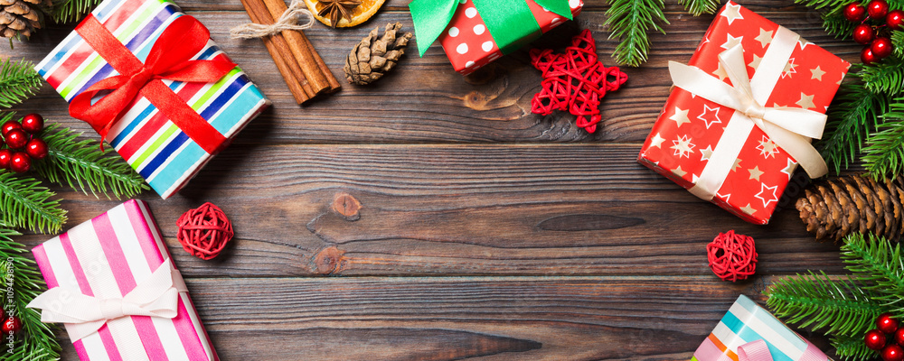 Top view of Christmas background made of fir tree, gifts and other decorations on wooden background. New year holiday concept with copy space Top view of Christmas background made of fir tree, gifts and other decorations on wooden background. New year holiday concept with copy space
