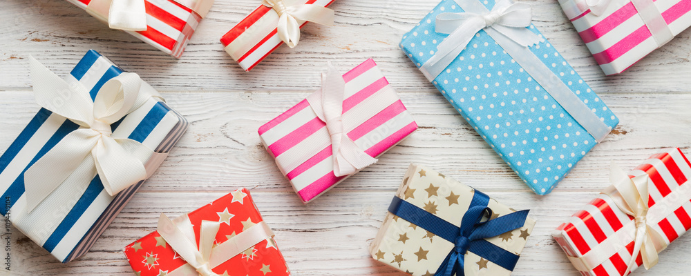 Fototapeta premium A lot of Christmas gift boxes in colored paper decorated on table, Top view close up. Many present New Year gift