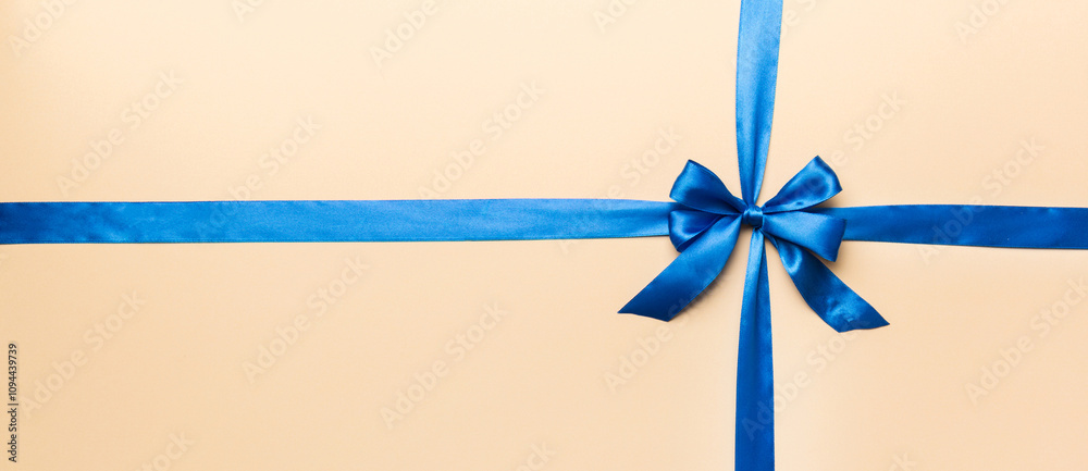 Top view of blue ribbon rolled and blue bow isolated on colored background. Flat lay with copy space Top view of blue ribbon rolled and blue bow isolated on colored background. Flat lay with copy space