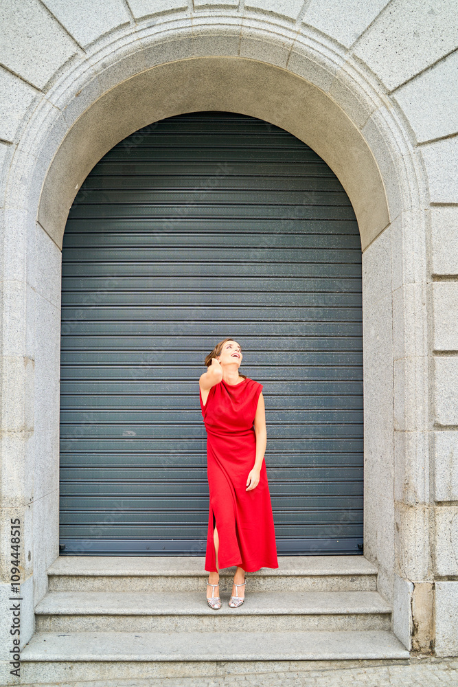 Woman in red dress standing under an archway Woman in red dress standing under an archway