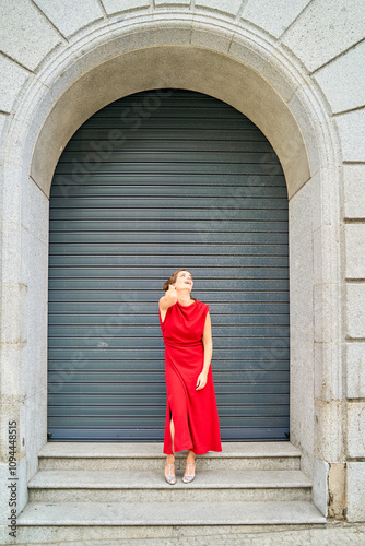 Woman in red dress standing under an archway