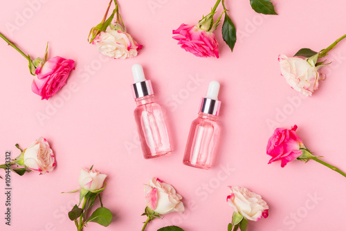 Rose essential oil on a textured background.Roses and a bottle of rose perfumed water.Aromatherapy treatment. Beauty concept. Spa procedure.Natural organic oil.Anti-stress,detox relax.Place for text