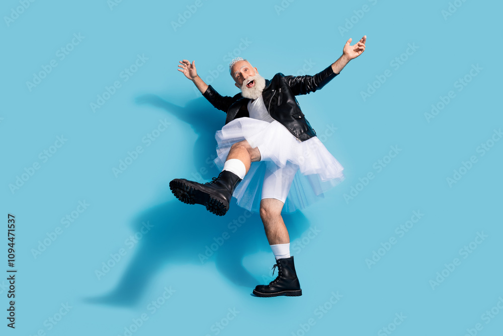 Photo of crazy senior transgender man dancing raise foot with black boots wear female clothes isolated blue color background Photo of crazy senior transgender man dancing raise foot with black boots wear female clothes isolated blue color background