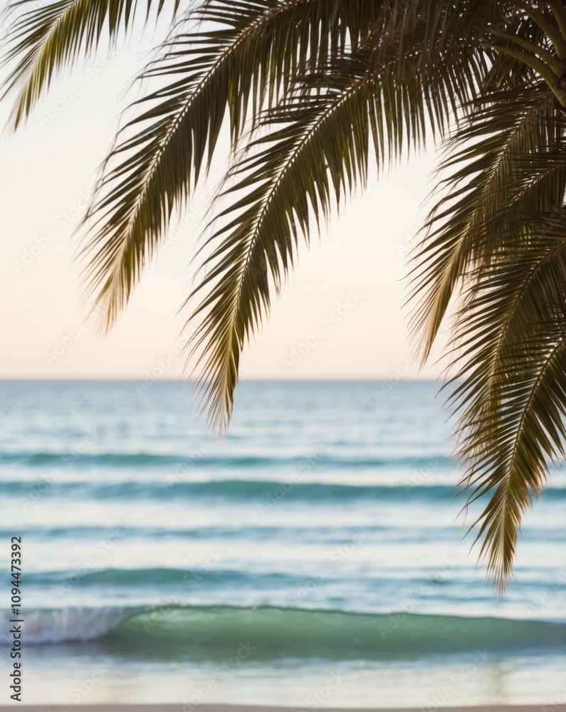 Fototapeta premium A tranquil beach view with palm fronds swaying gently over the shimmering turquoise waves.