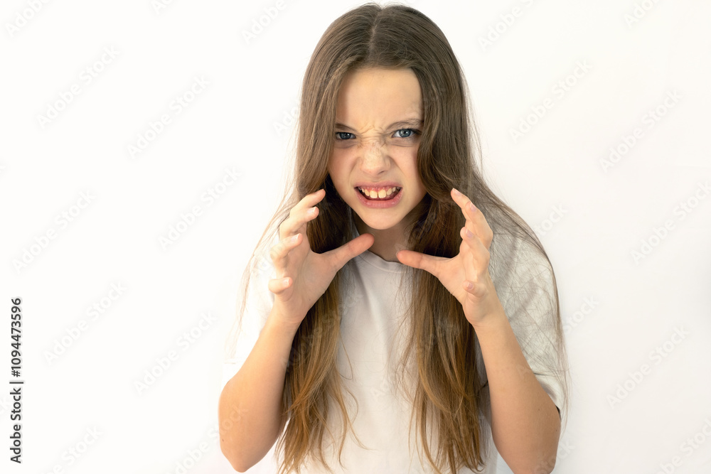 Beautiful teenage girl in white t-shirt on white background getting angry. Emotions in teenagers, anger and aggression Beautiful teenage girl in white t-shirt on white background getting angry. Emotions in teenagers, anger and aggression