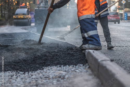 Fotografia Road construction worker leveling asphalt with a shovel