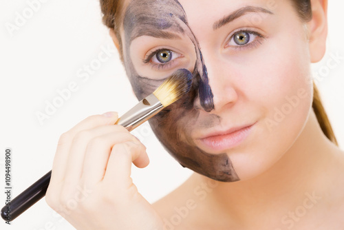 Woman being apply black carbo mask to face