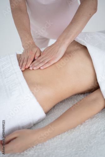 A woman receiving a belly massage at a beauty salon