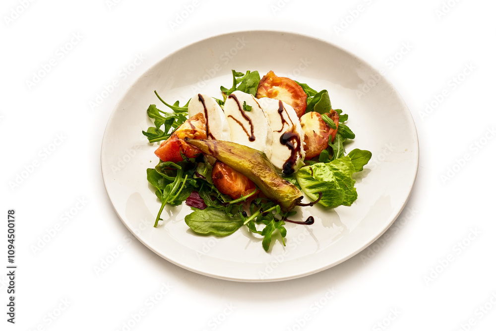 A white plate with a salad of tomatoes, cucumbers, and basil A white plate with a salad of tomatoes, cucumbers, and basil